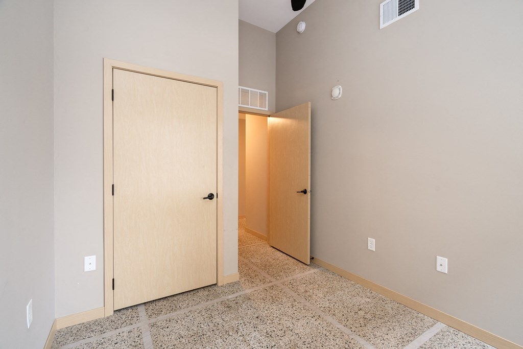 an empty room with two doors and a tiled floor