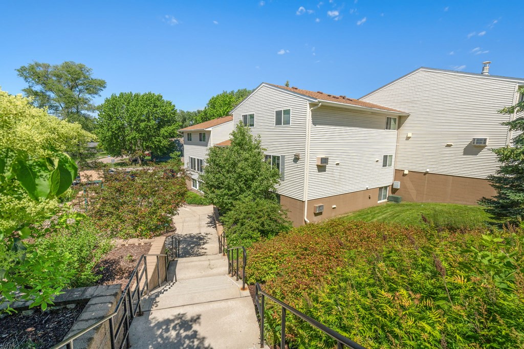 a house on a hill with stairs and a sidewalk