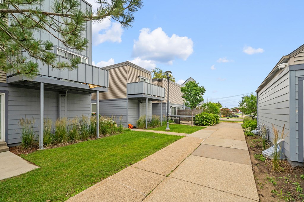 a sidewalk in front of a row of houses