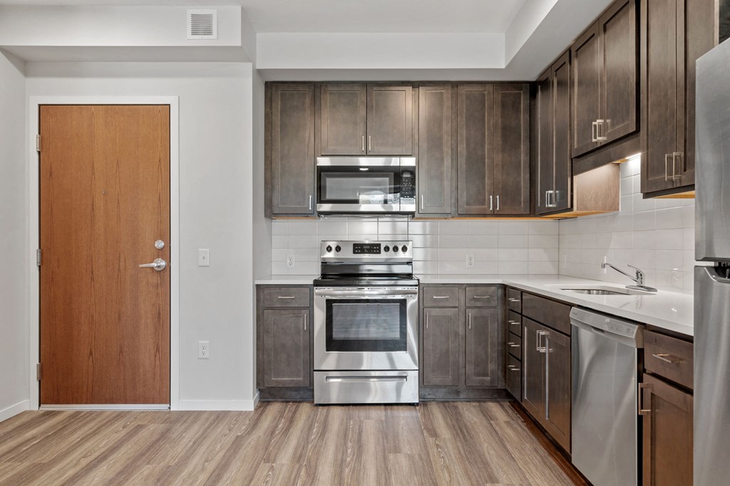 a kitchen with wooden cabinets and stainless steel appliances