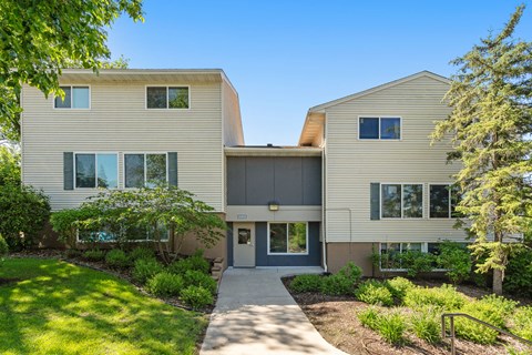 the front of a house with a sidewalk and trees