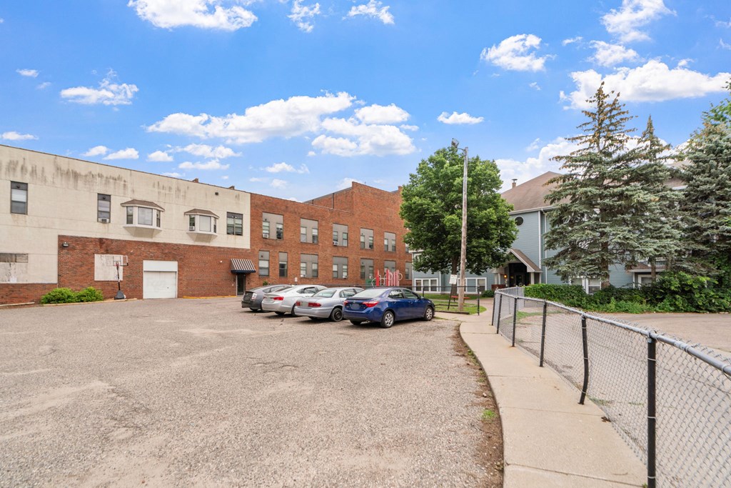 a parking lot with cars in front of a brick building