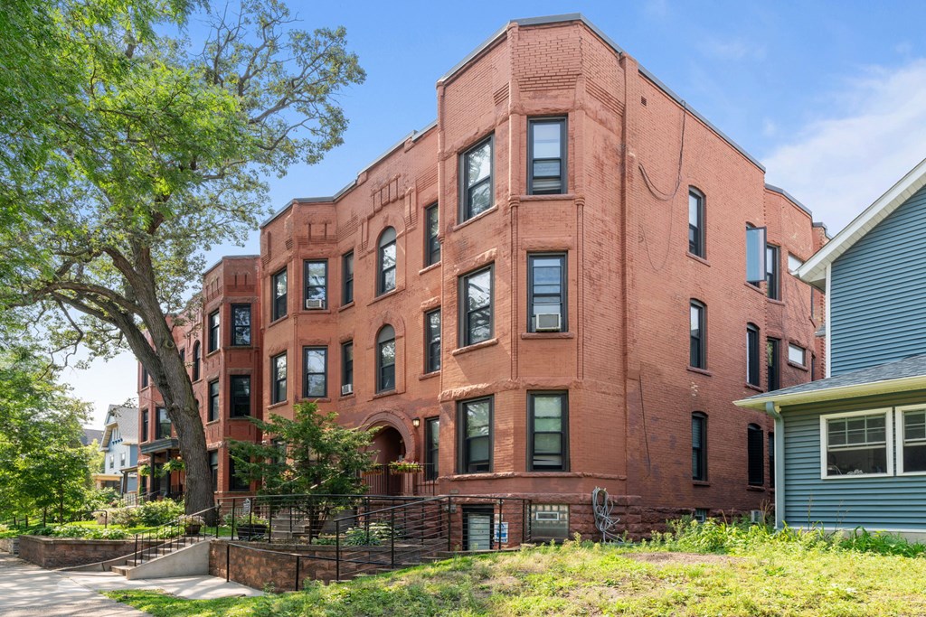 a red brick building with a tree in front of it
