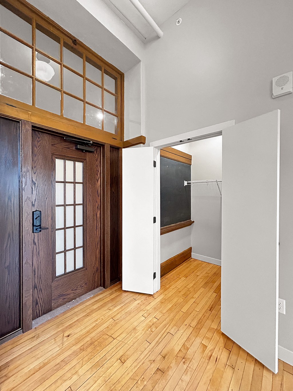 a renovated living room with a wooden door and a white closet