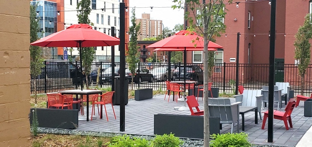 a patio with tables and chairs and umbrellas