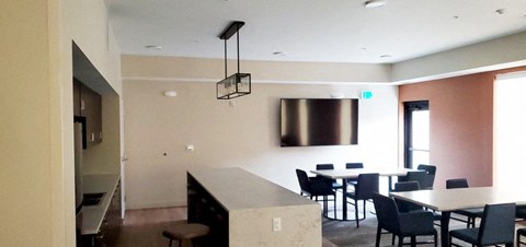 a dining room with tables and chairs and a tv on the wall