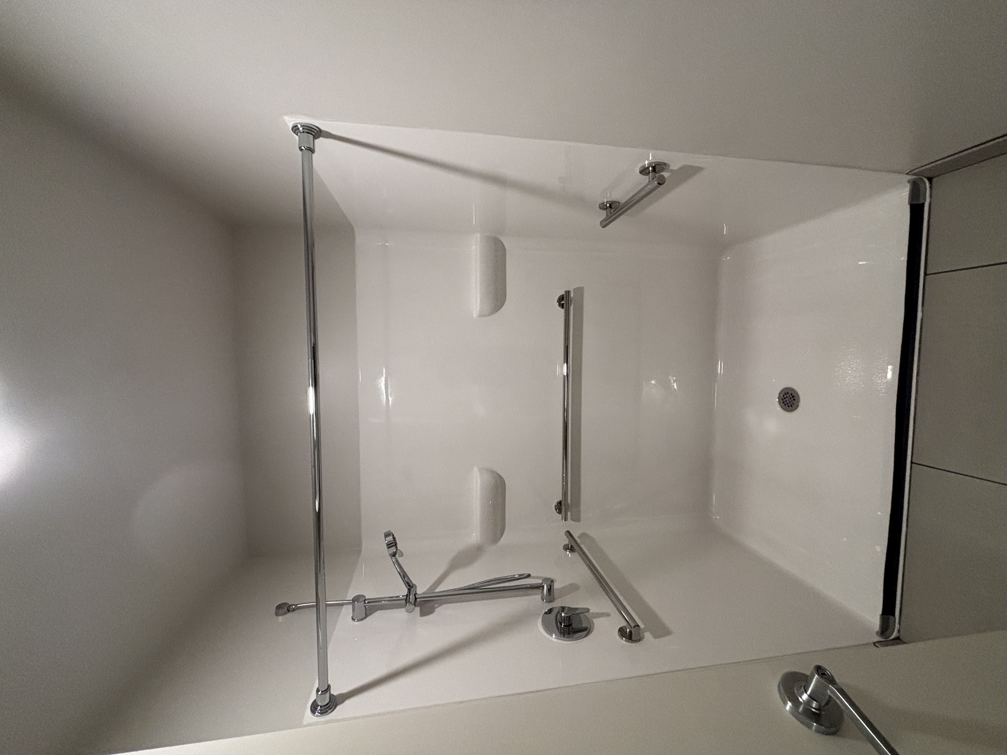 A white bathroom with a shower and a white tub.