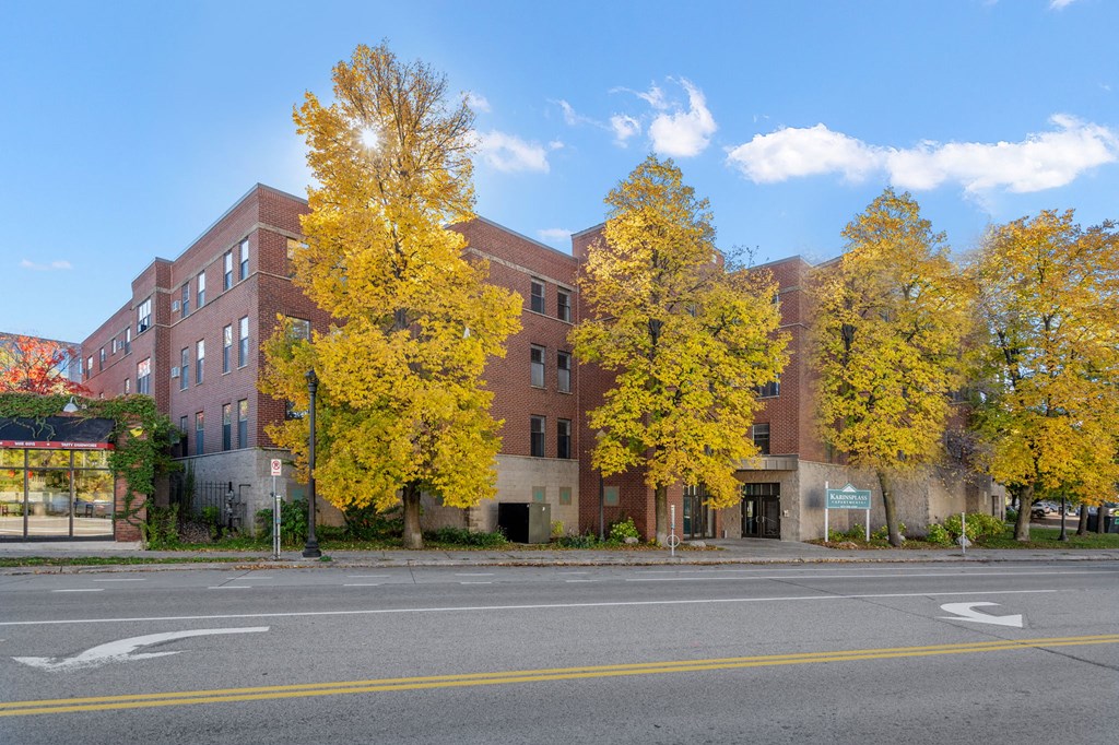 a red brick building on a street corner with yellow trees