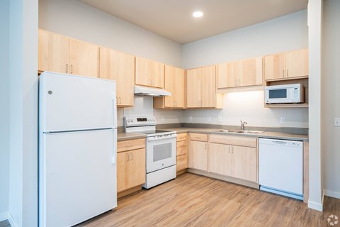 A kitchen with wooden cabinets and white appliances.