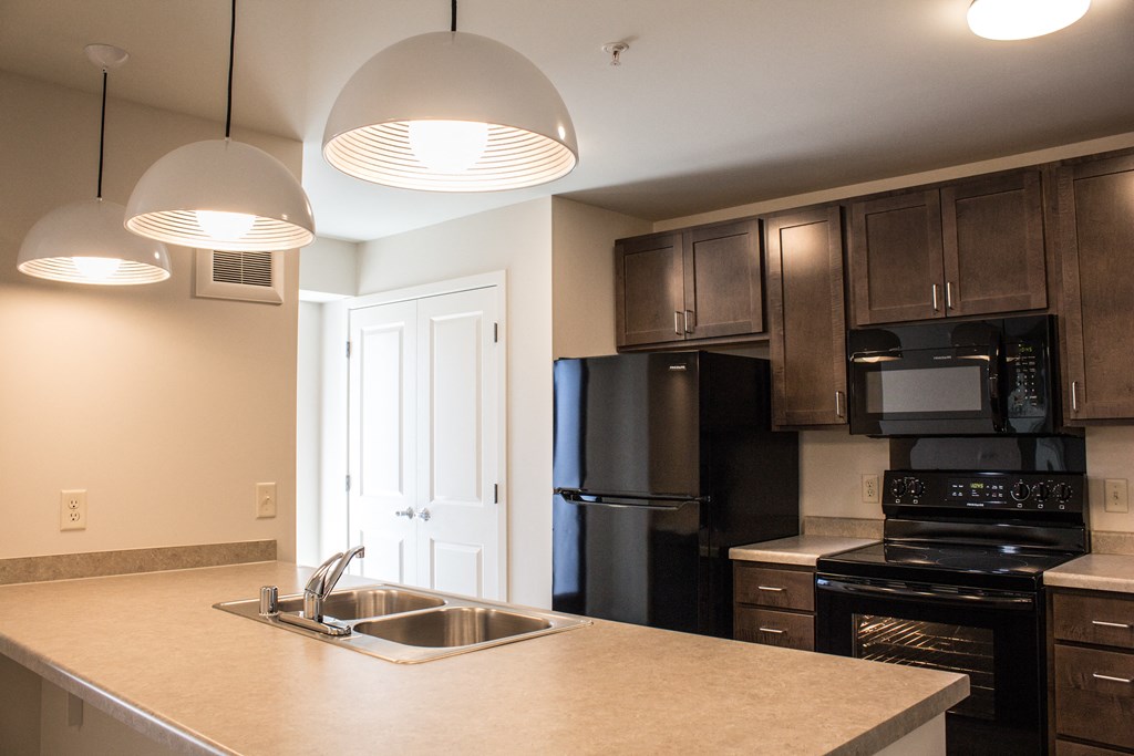 a kitchen with black appliances and a counter top with a sink