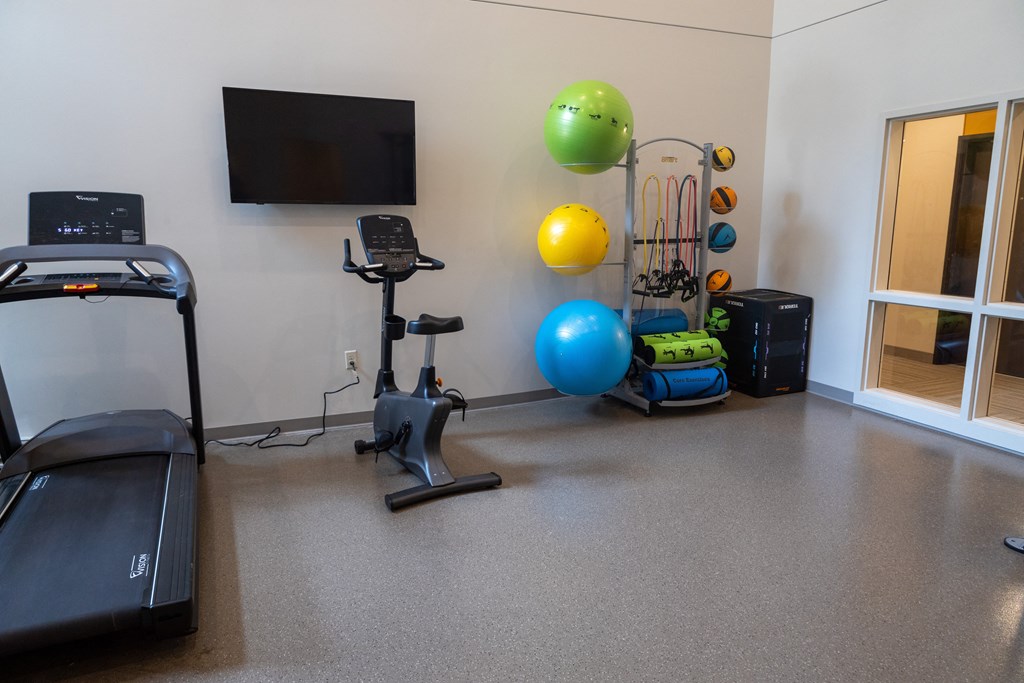 a workout room with exercise equipment and a tv
