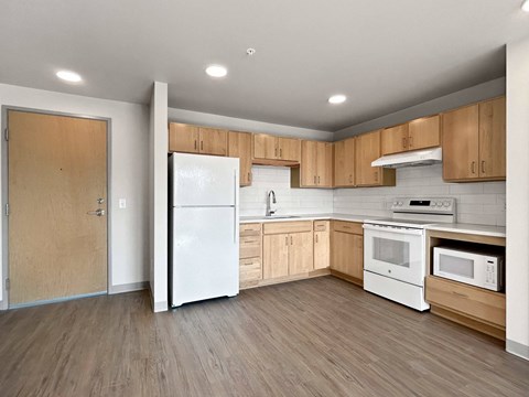 a kitchen with white appliances and wooden cabinets
