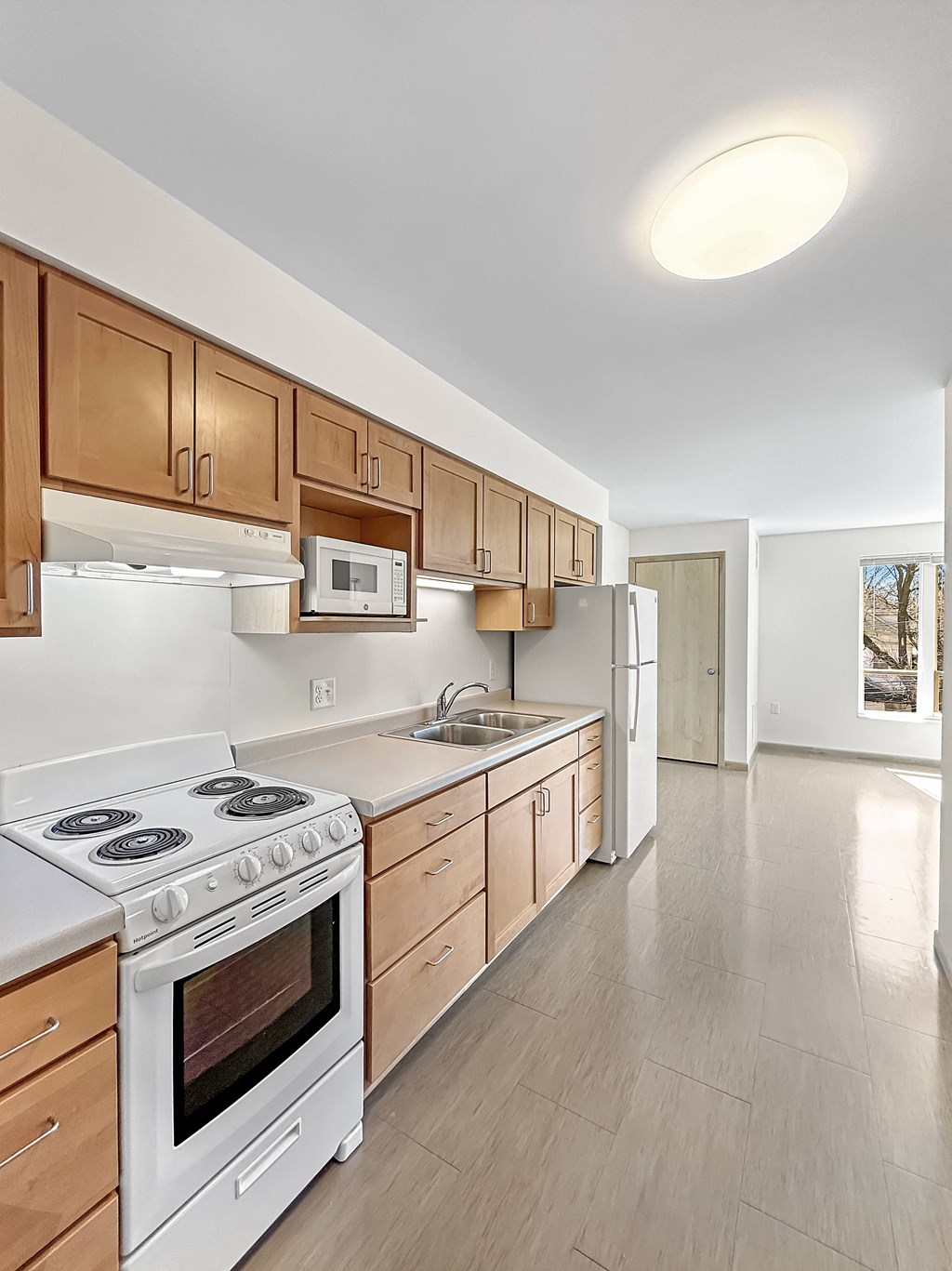 a kitchen with white appliances and wooden cabinets