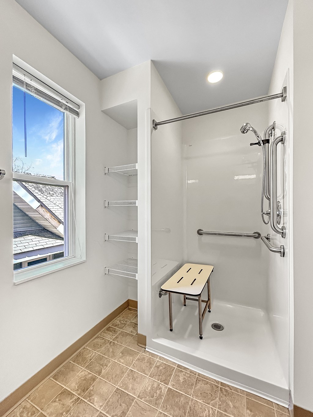 a white bathroom with a shower and a window