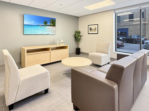 A waiting room with a flat screen TV mounted on the wall.
