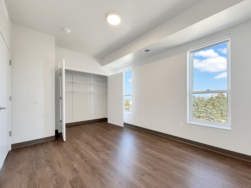 A room with a sliding door and a window showing a tree.
