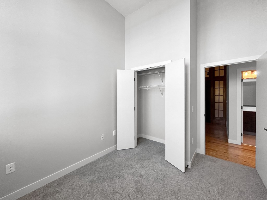 an empty room with white walls and a closet in it