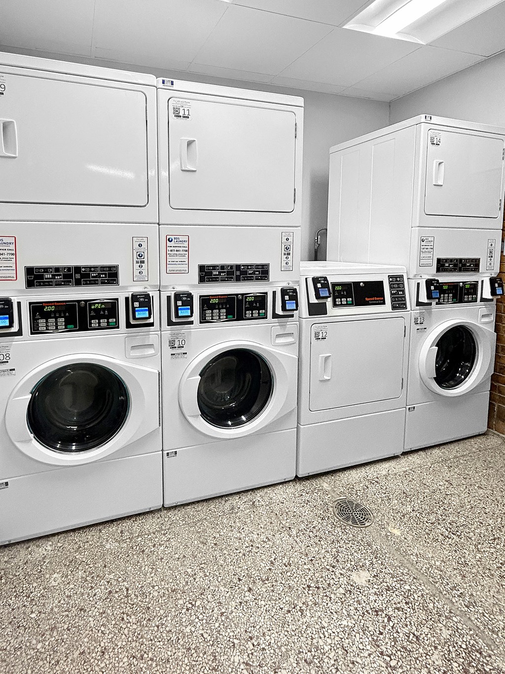 a row of washers and dryers in a laundry room