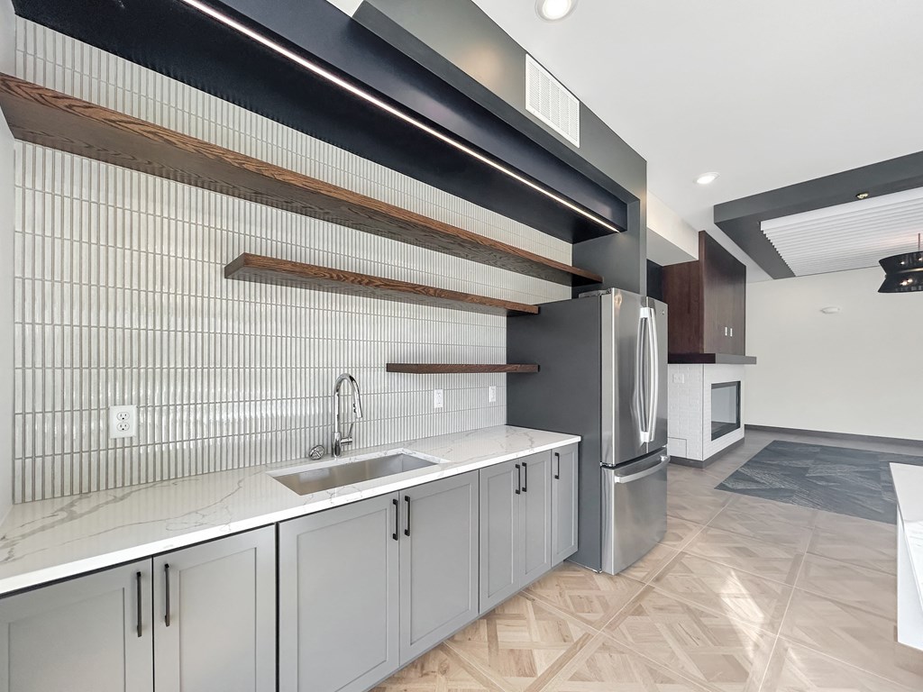 a kitchen with white cabinets and a stainless steel refrigerator