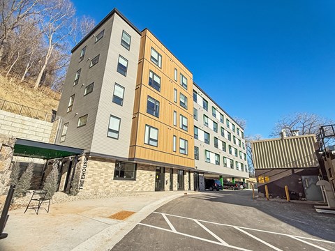 A modern building with a parking lot in front.