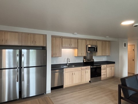 A modern kitchen with wooden cabinets and stainless steel appliances.