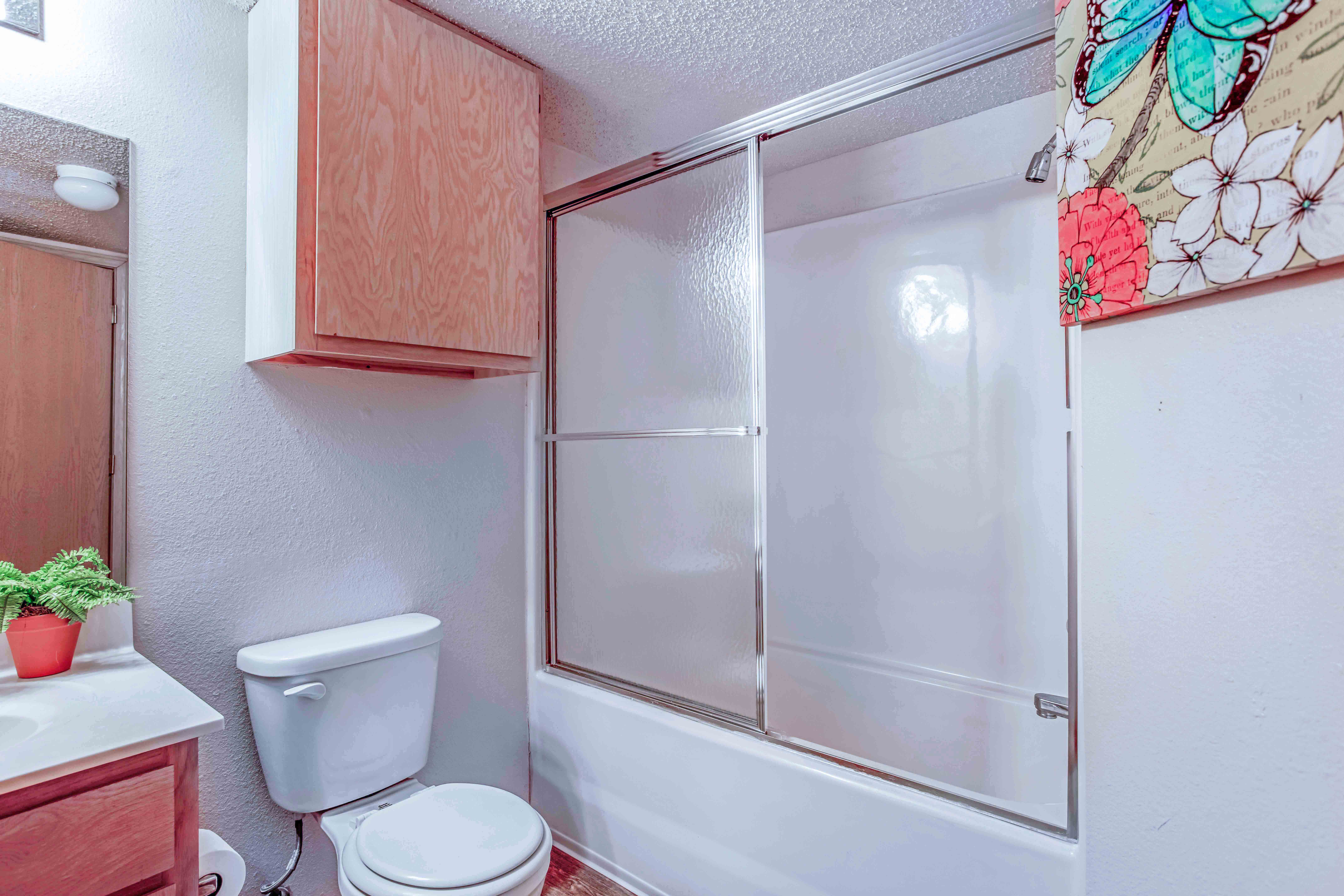 a bathroom with a white toilet next to a white bathtub