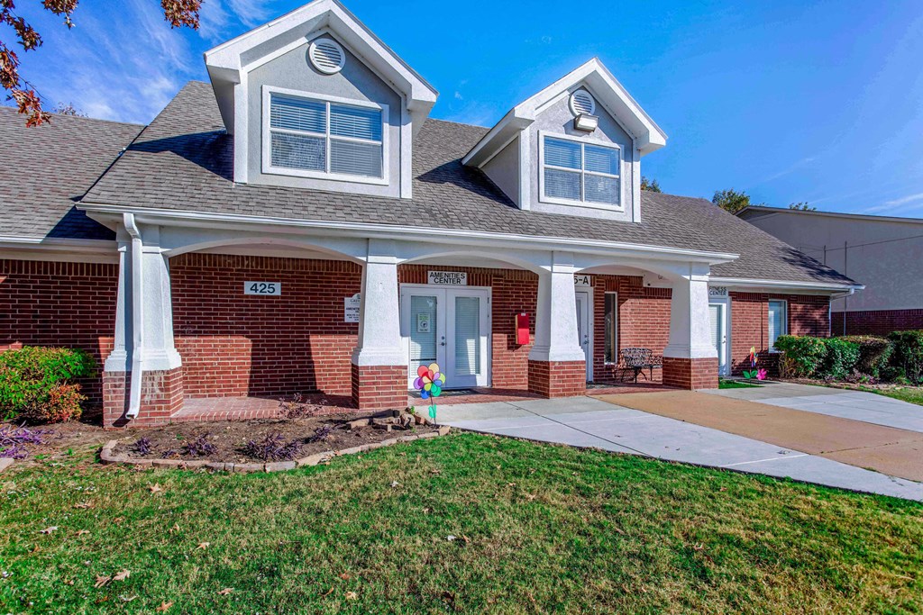 the front of a brick house with a sidewalk in front of it
