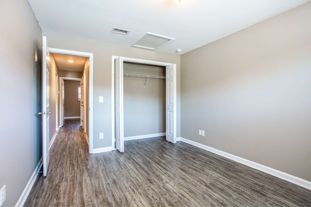 a empty room with a hallway and a closet