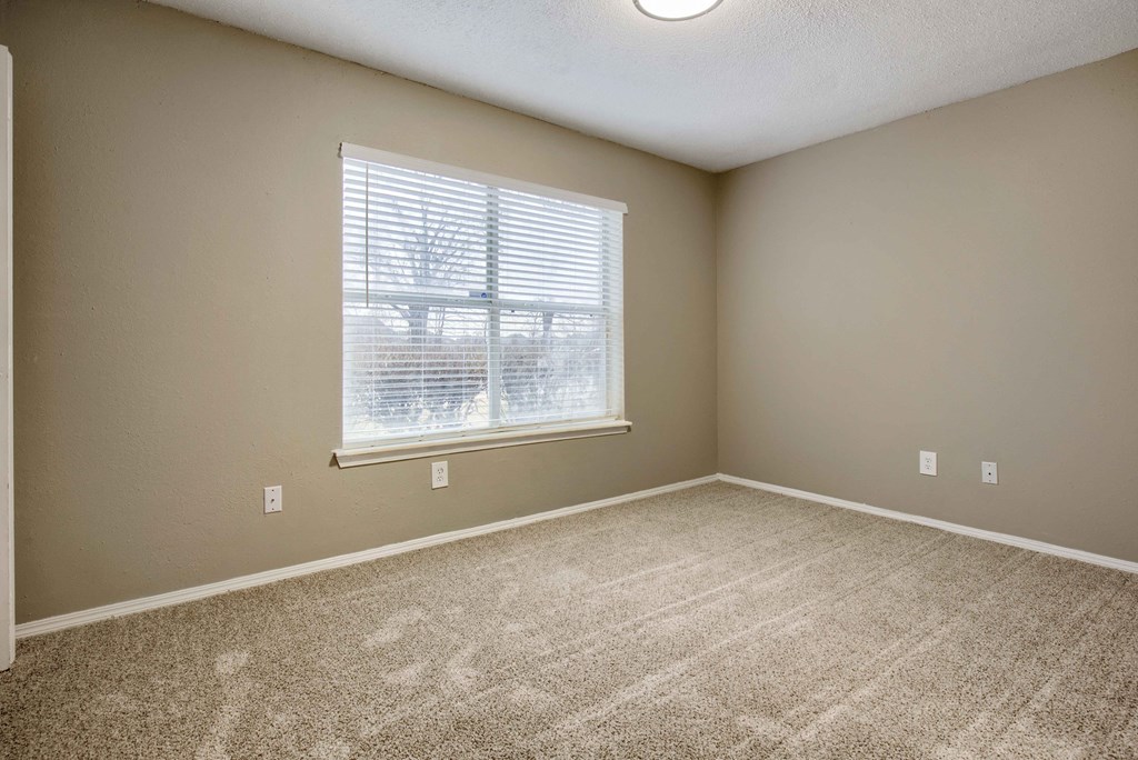 an empty bedroom with a large window
