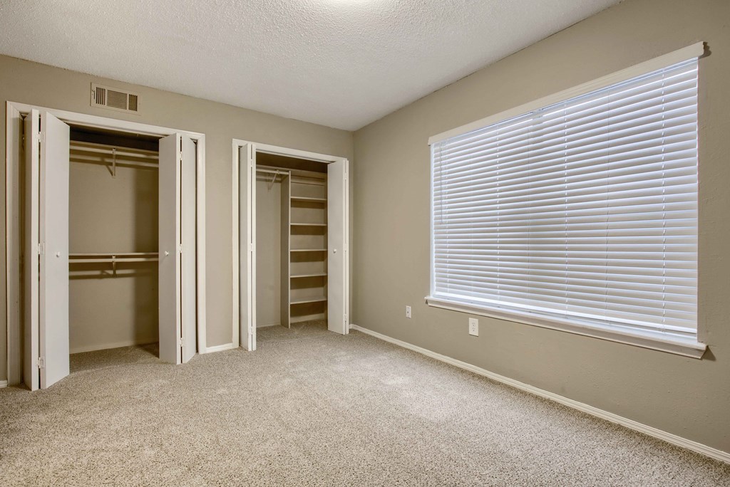 a bedroom with a large window and a closet