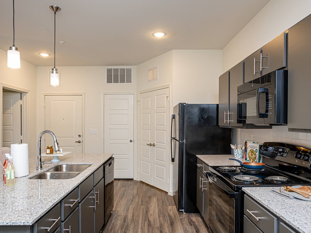 a kitchen with black appliances and granite counter tops