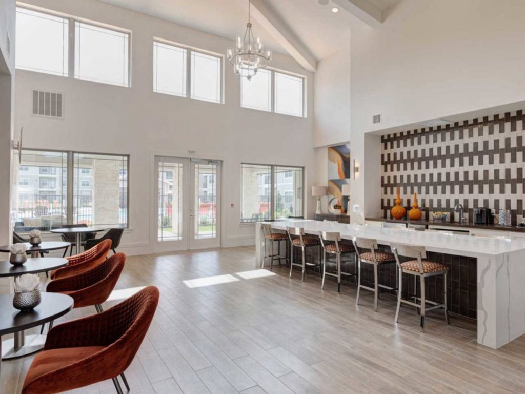 a large room with a bar and chairs