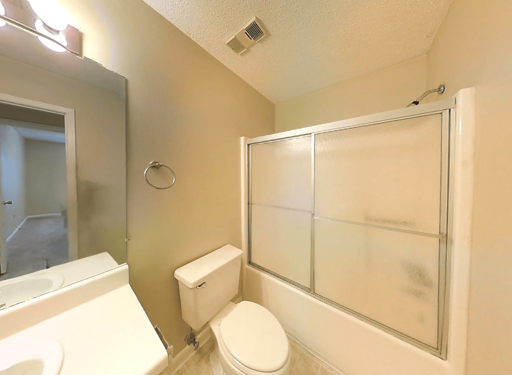 a bathroom with a white toilet and a glass shower