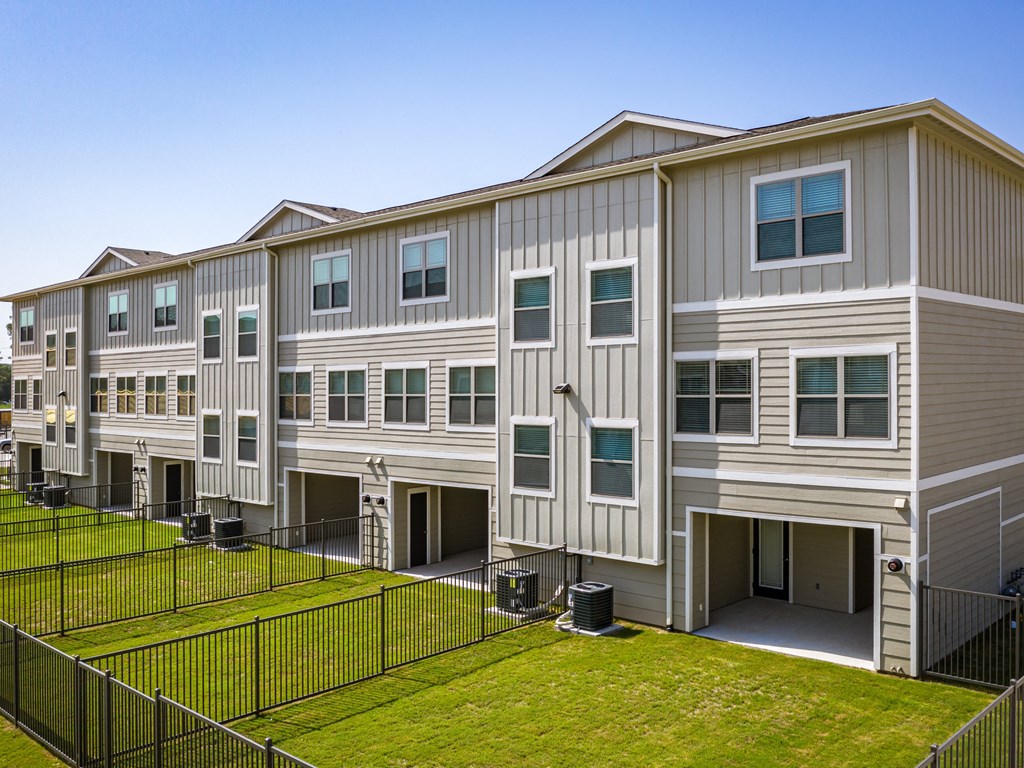 an image of an apartment building with a grassy yard