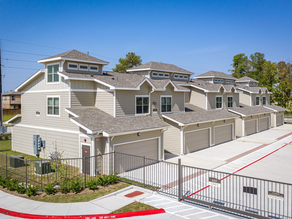 a row of houses in a neighborhood with a sidewalk and gate