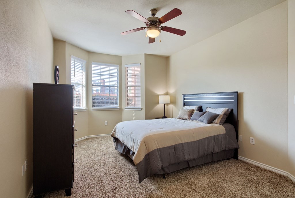 a bedroom with a bed and a ceiling fan