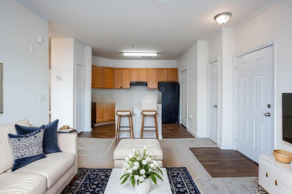 A living room with a white couch and a wooden cabinet.