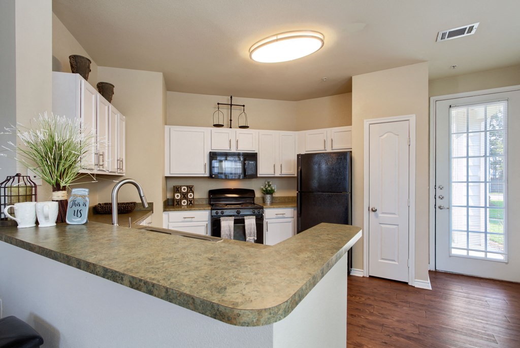 a kitchen with white cabinets and a granite counter top