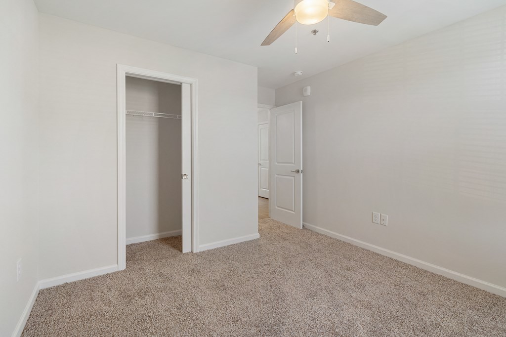 a bedroom with a closet and a ceiling fan