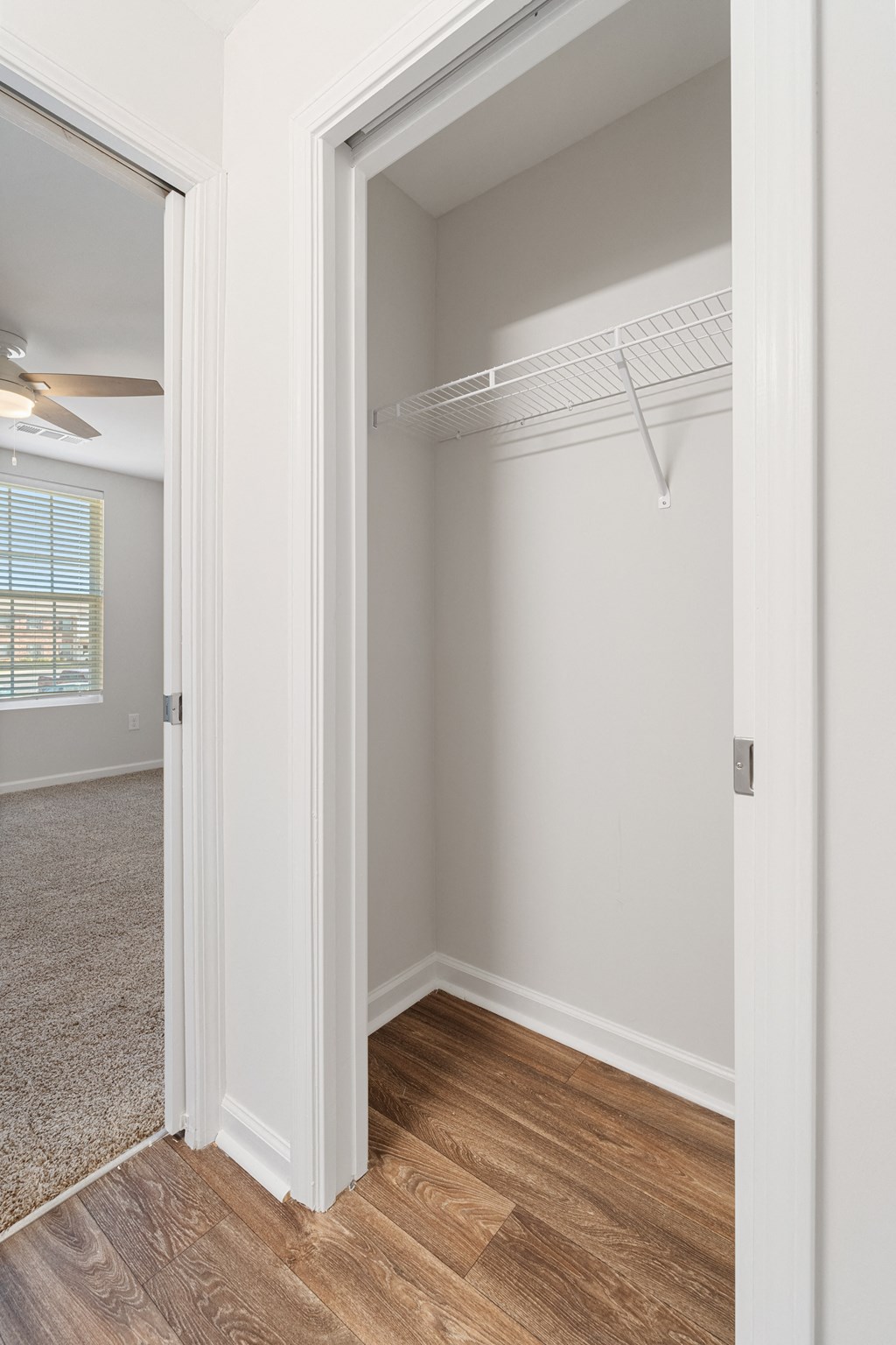 an empty bedroom with a closet with a mirrored closet door