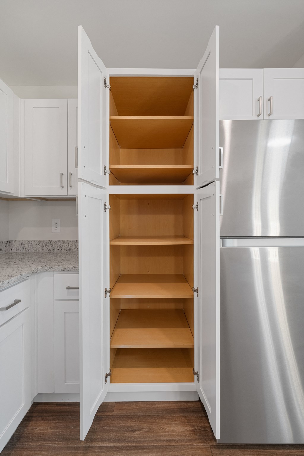 a kitchen with white cabinets and stainless steel appliances and an open refrigerator