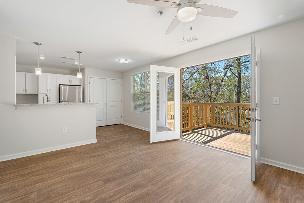 an open living room and kitchen with a sliding glass door to a balcony
