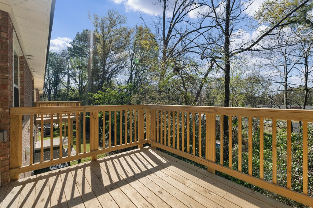 the deck has a view of the backyard and the trees
