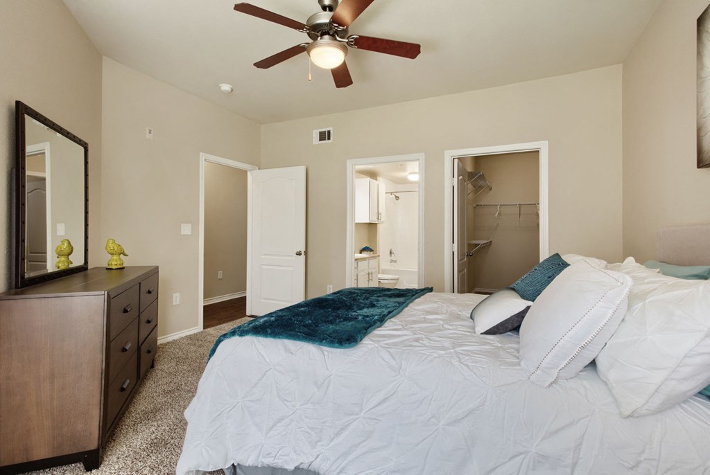 a bedroom with a large bed and a ceiling fan