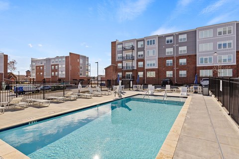 A swimming pool in front of apartment buildings.