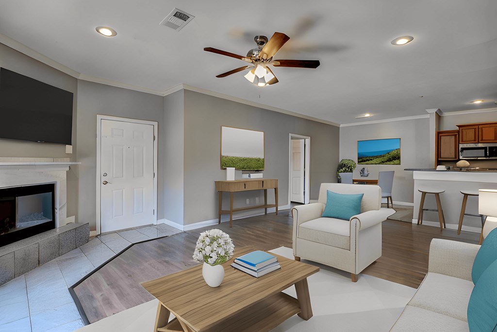 A living room with a fireplace, a couch, a coffee table, and a ceiling fan.