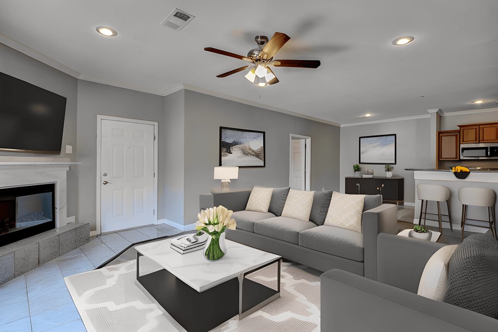 A modern living room with a fireplace and a grey sofa.