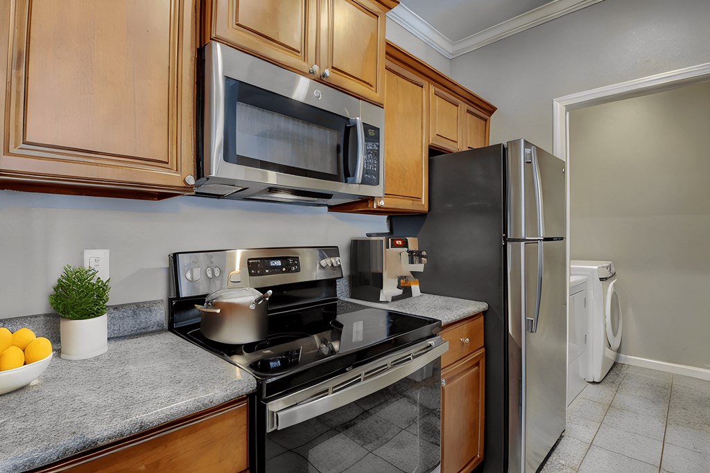 A kitchen with a stove, microwave, and refrigerator.