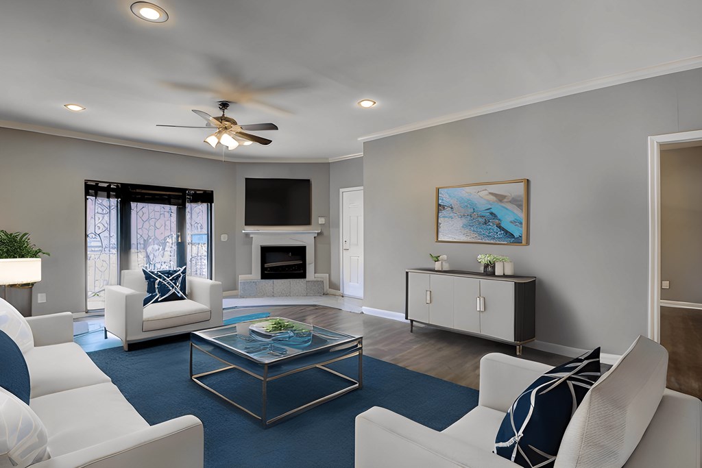 A living room with a white couch, a glass coffee table, and a painting on the wall.