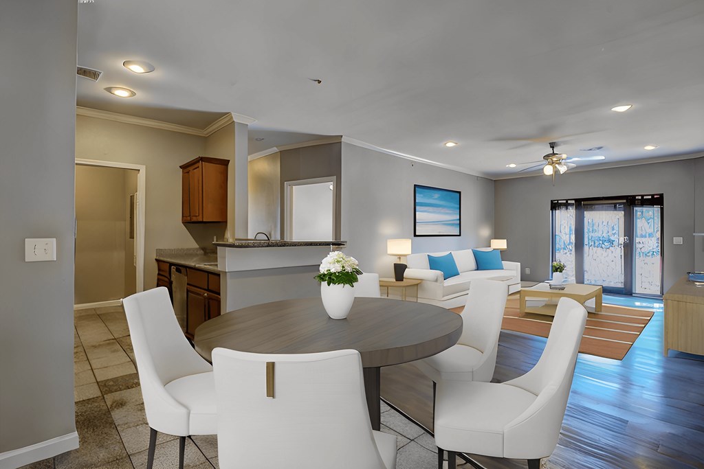 A modern dining room with a round table and white chairs.